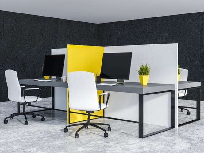 White and yellow office cubicles with gray computer tables and white chairs standing in room with black walls and concrete floor. 3d rendering